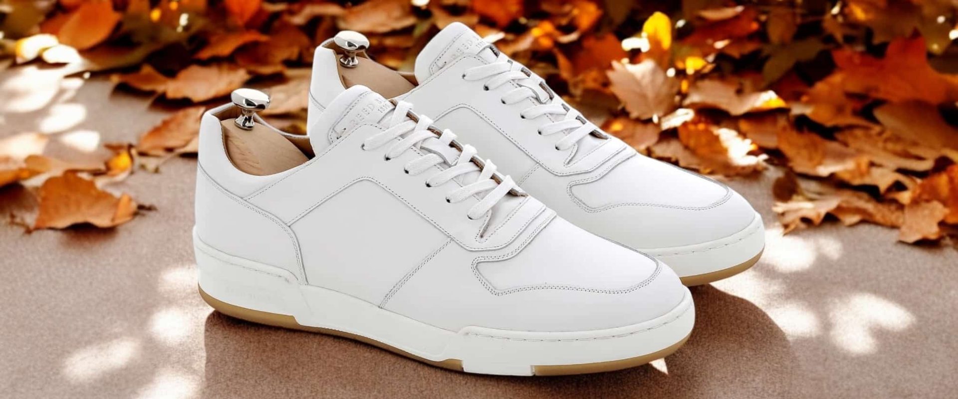 Chaussures blanches sur fond de feuilles d'automne.