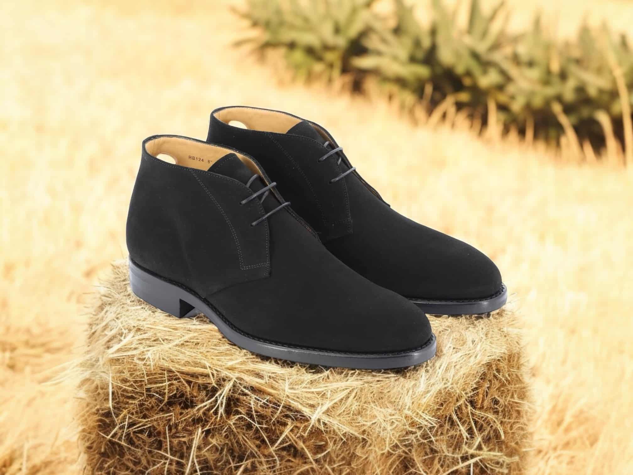 Chaussures noires sur botte de foin